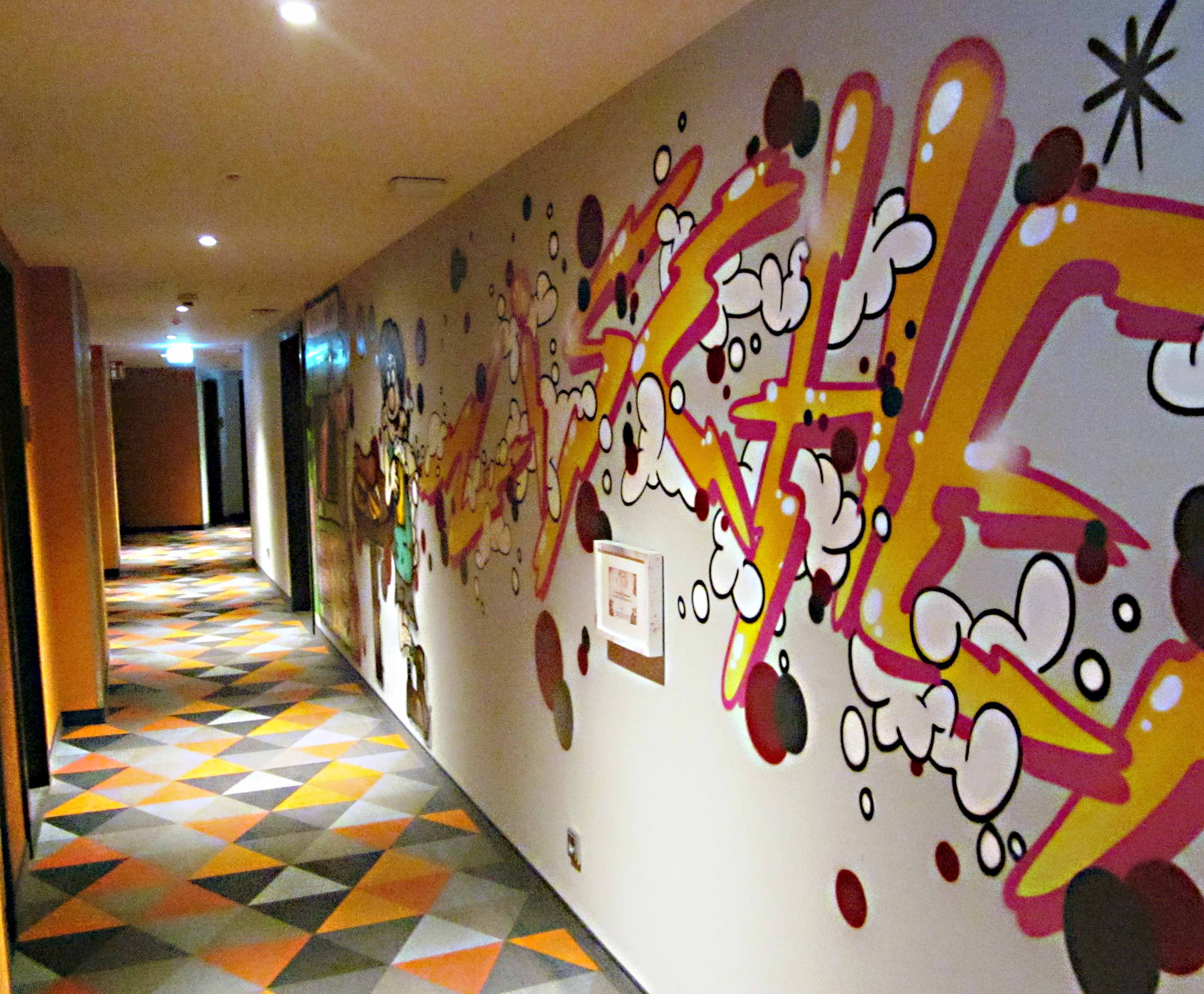 Poppig-schrill sind auch die Wände und Bodenbeläge in den Hotelgängen gestaltet.