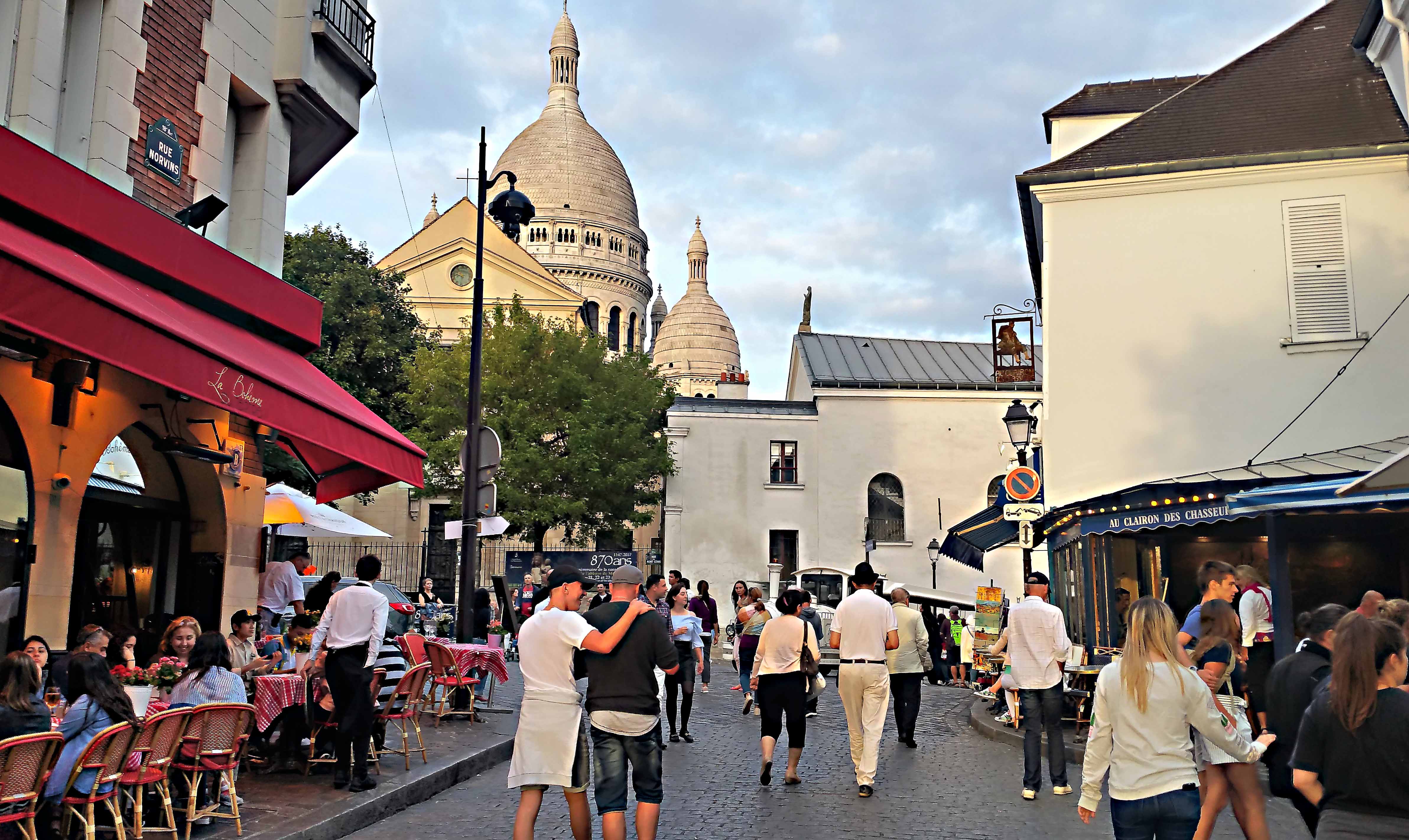 Stimmungsvolles Künstlerviertel Montmartre mit der Kirche Sacré-Coeur im Hintergrund.