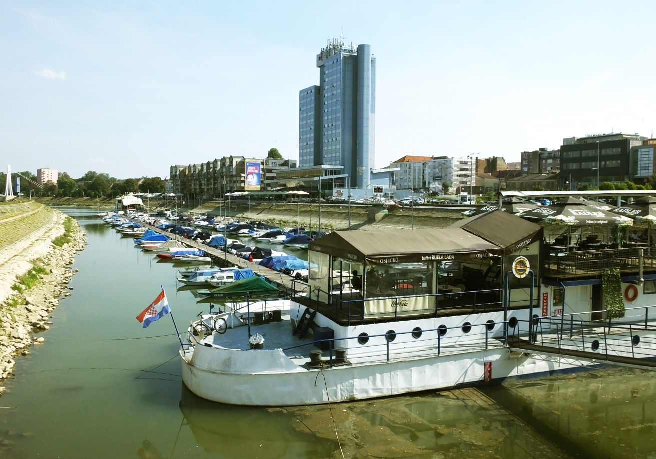 Hinter dem kleinen Yachthafen an der Drau prägt das imposante „Hotel Osijek“ die Stadtsilhouette.